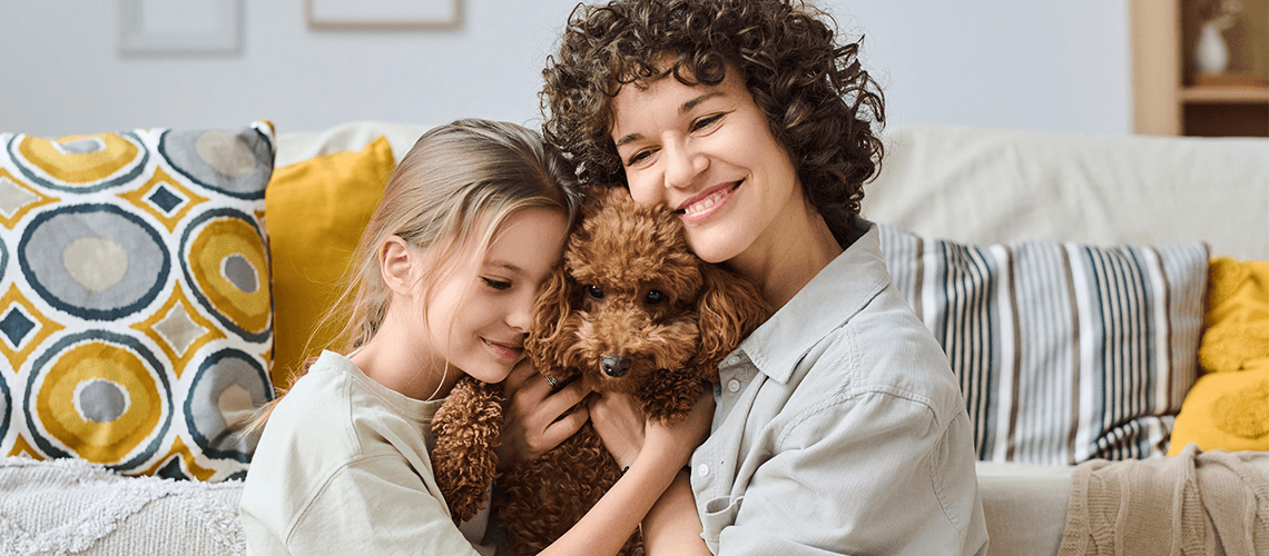 woman and girl cuddling dog